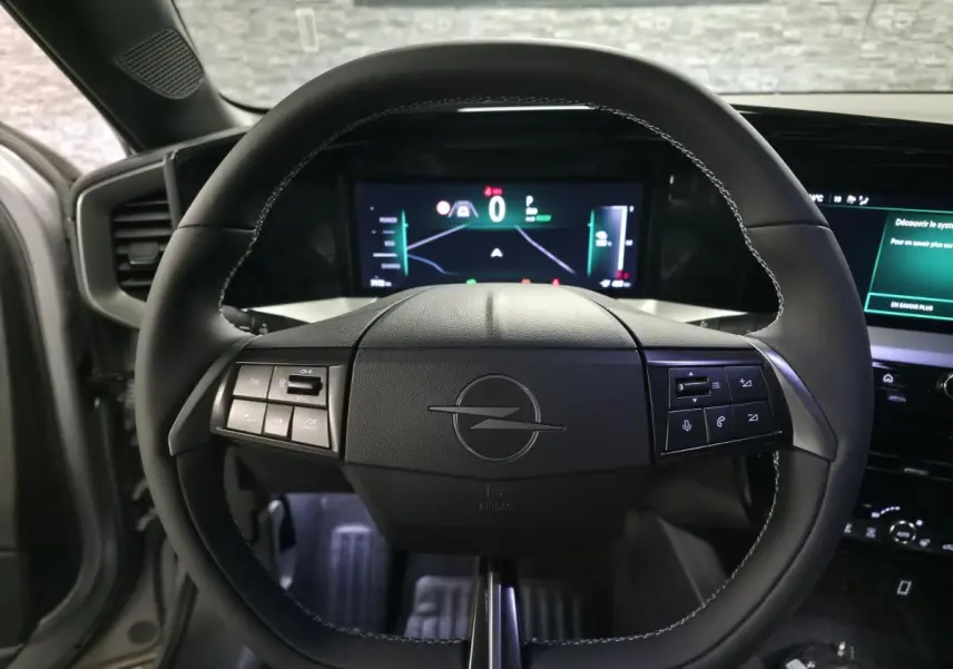 Vue rapprochée du volant noir de l’Opel Mokka-e 2025 avec tableau de bord digital et commandes intégrées.