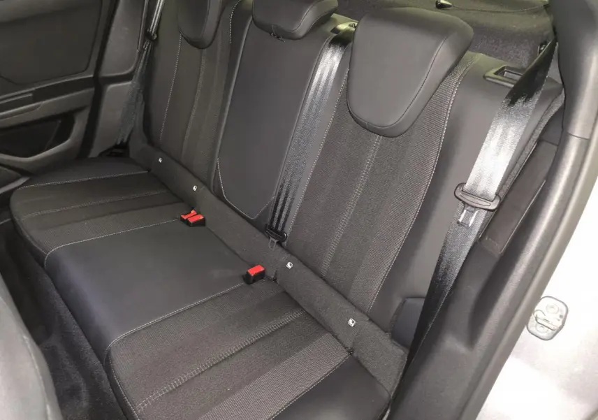 Vue rapprochée de la banquette arrière noire de l'Opel Mokka-e 2025 avec ceintures et appuie-têtes intégrés.