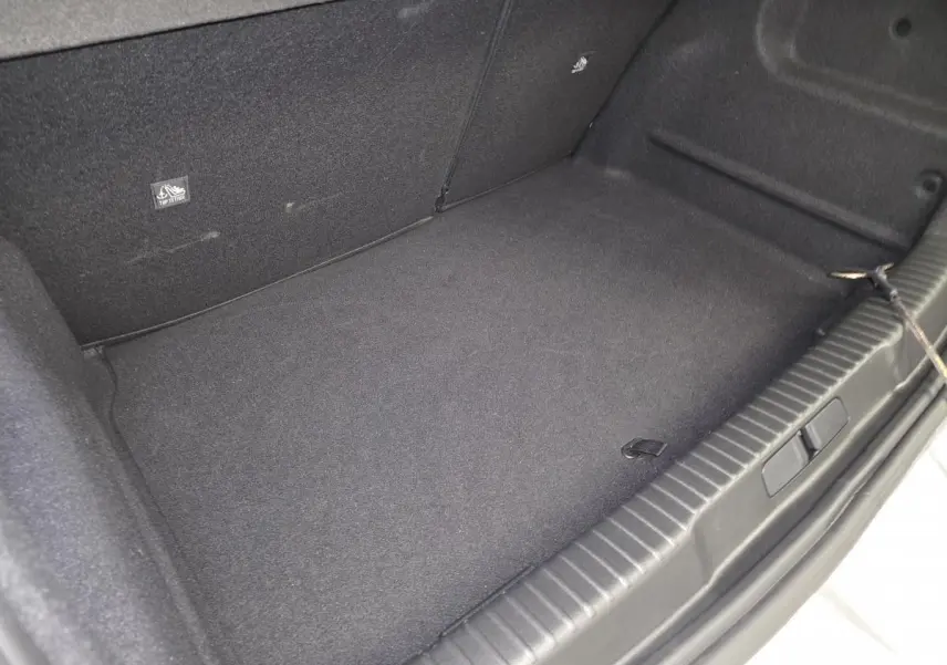 Coffre spacieux et propre de l’Opel Mokka-e gris, vue intérieure depuis l’ouverture arrière.