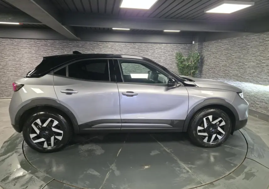 Opel Mokka-e 2025 gris, vue de profil côté gauche, avec toit noir et jantes alliage diamantées 17 pouces.