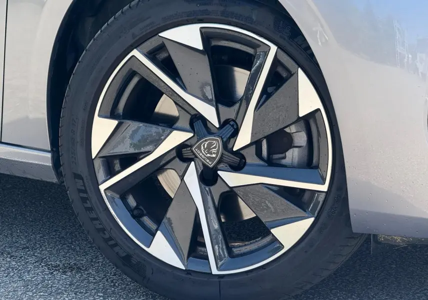 Vue 3/4 arrière droite d'une Peugeot 308 gris Artense avec feux LED et jantes alliage distinctives.