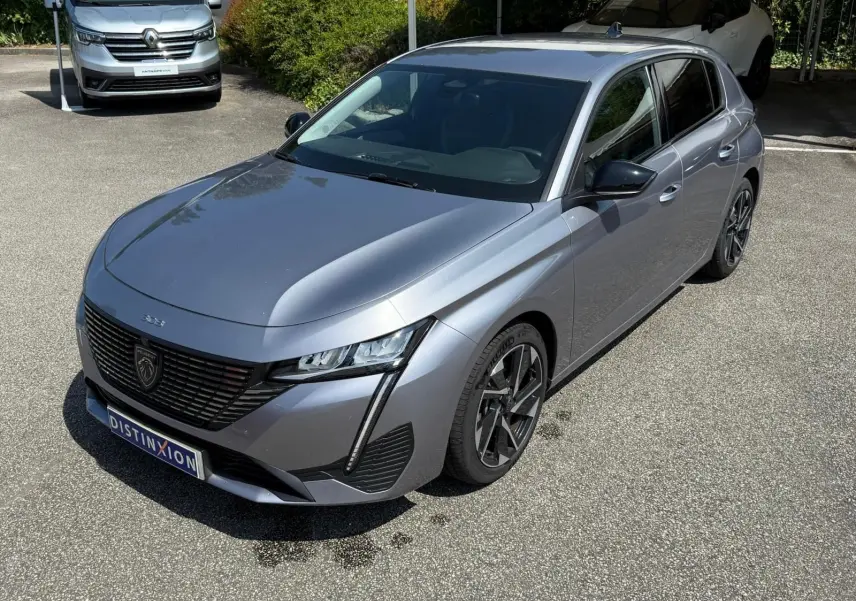 Peugeot 308 gris Artense vue 3/4 avant droit, mettant en valeur ses phares LED et sa calandre noire distinctive.