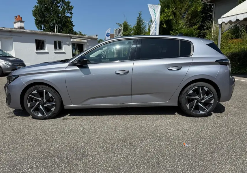 Profil côté gauche d'une Peugeot 308 2024 gris Artense avec jantes alliage au design moderne.