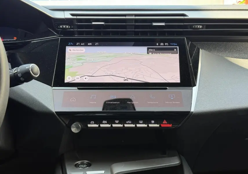 Vue rapprochée du tableau de bord de la Peugeot 308 2024 avec écran tactile affichant la navigation et commandes tactiles.