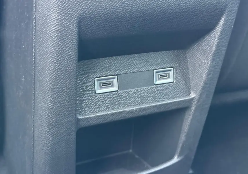 Gros plan sur deux ports USB intégrés dans la console arrière d'une Peugeot 308 gris Artense 2024.