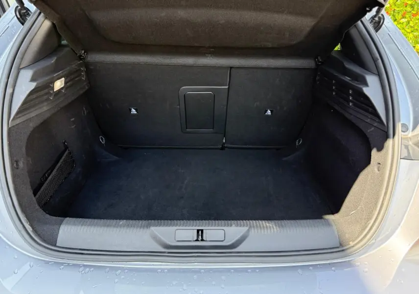 Coffre ouvert d'une Peugeot 308 gris Artense, vue arrière montrant un espace de chargement propre et spacieux.