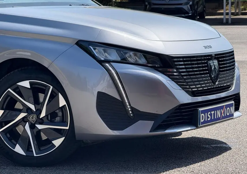 Gros plan sur la jante avant droite de la Peugeot 308 gris Artense avec un design moderne bicolore.