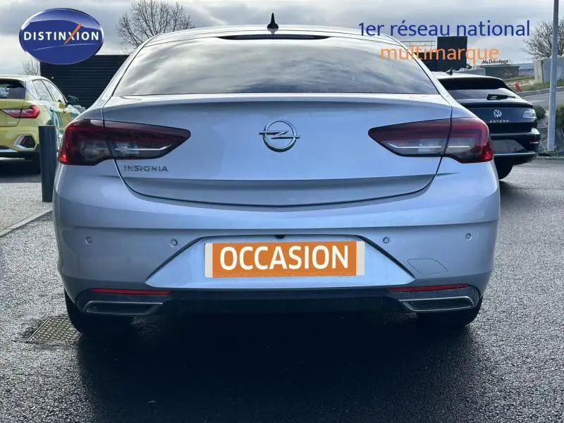 Vue arrière d'une Opel Insignia Grand Sport blanc glacier avec feux arrière LED et double sortie d'échappement chromée