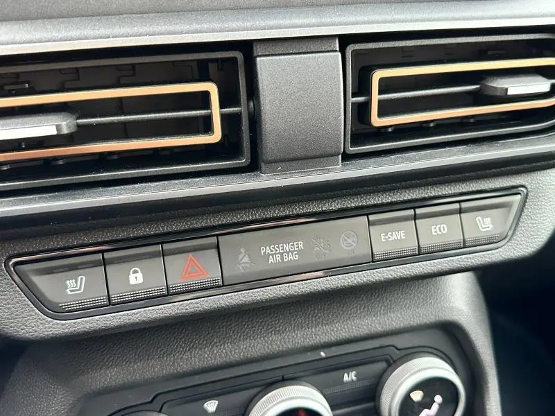 Gros plan sur la console centrale du Dacia Jogger 2025, boutons de siège chauffant, verrouillage, et modes Eco visibles.