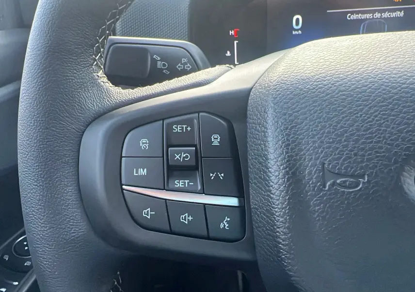 Gros plan sur les commandes au volant du Ford Ranger 2025, version Tremor Cover, avec boutons de régulateur et volume.