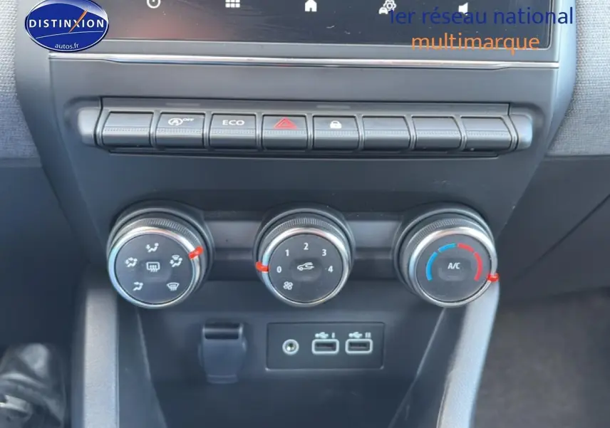 Vue rapprochée de la console centrale de la Renault Clio V 2025 gris métal, avec commandes climatisation et ports USB visibles.