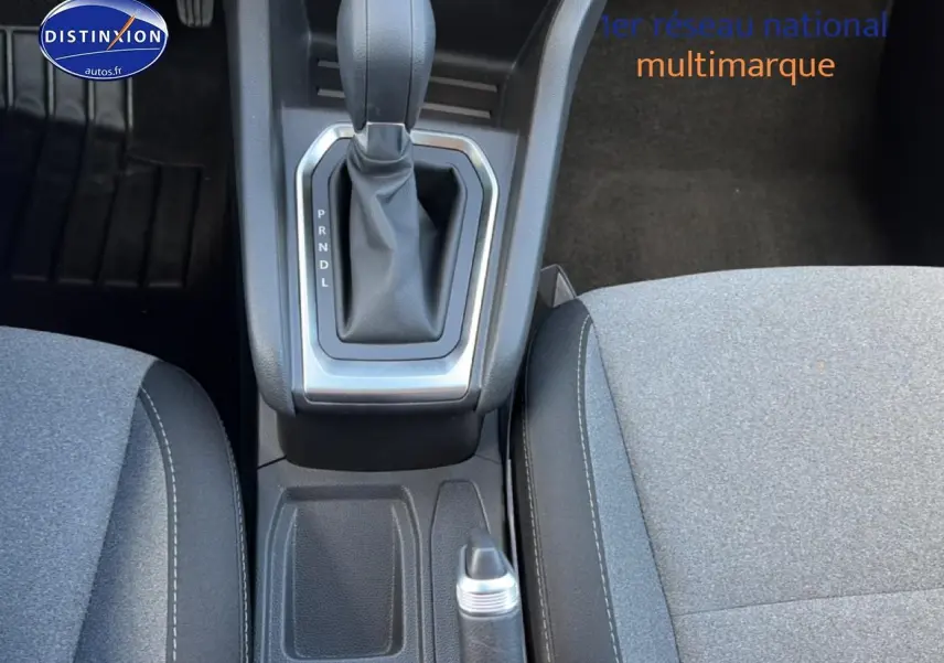 Vue plongeante sur la console centrale et levier de vitesse d’une Renault Clio V gris métal, intérieur tissu gris.