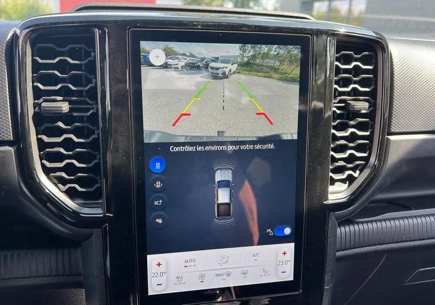 Écran tactile central du Ford Ranger 2025 gris iconic montrant la caméra de recul et les commandes de climatisation.