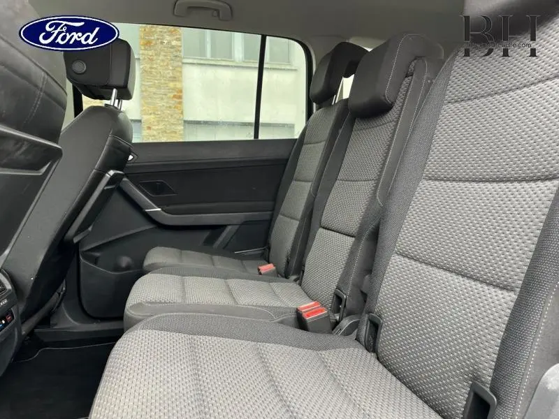 Vue latérale des sièges arrière en tissu noir du Volkswagen Touran 2.0 TDI, mettant en valeur la 2e rangée coulissante.