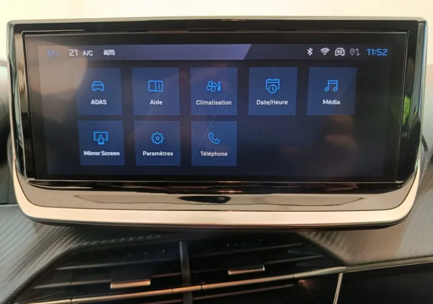 Écran tactile central affichant les menus de climatisation et médias dans l’habitacle d’une Peugeot 208 gris clair.