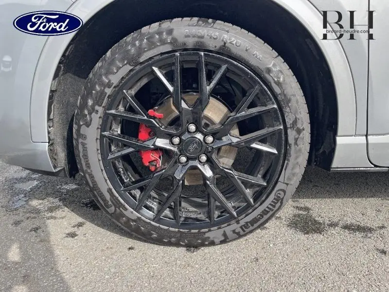 Gros plan sur la roue avant gauche du Ford Kuga gris Solar, jante alu noire et étrier de frein rouge visible.