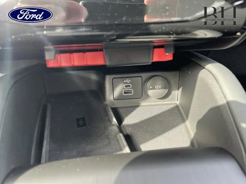 Gros plan intérieur sur la console centrale du Ford Kuga 2026, montrant prises USB-C et prise 12V avec rangement noir.