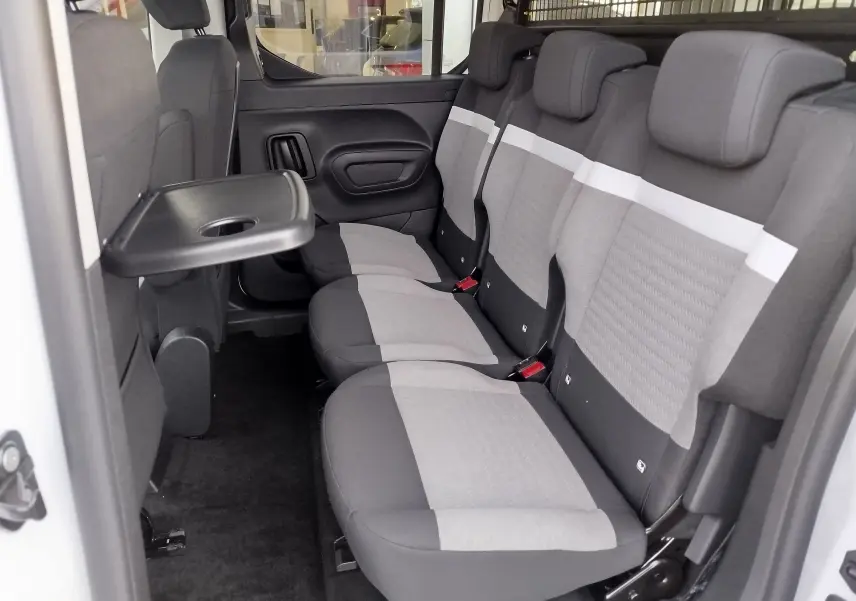 Vue intérieure côté droit du Citroën Berlingo 2025 Kaolin White, montrant la banquette arrière 3 places avec tablette rabattable.