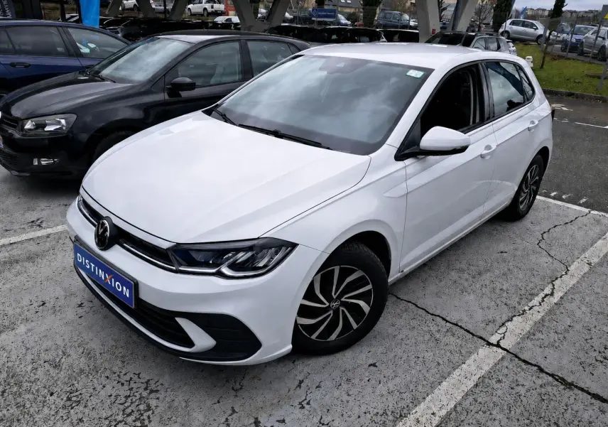 Volkswagen Polo 1.0 TSI blanche vue en 3/4 avant droit sur parking avec jantes noires et blanches.