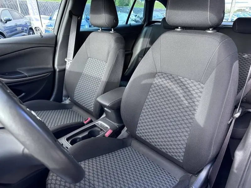 Vue intérieure de l'Opel Astra Sports Tourer 2021 montrant les sièges avant en tissu noir avec motifs géométriques.