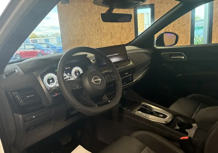 Vue intérieure côté conducteur du Nissan Qashqai 2025 avec tableau de bord numérique et finition noire élégante.