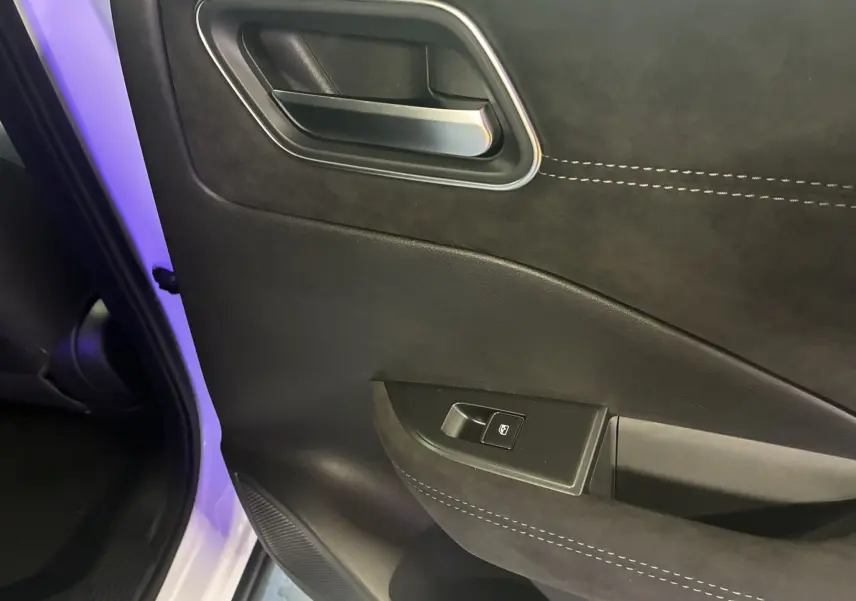 Gros plan sur la porte arrière gauche intérieure du Nissan Qashqai blanc nacré avec garniture noire et surpiqûres contrastées.