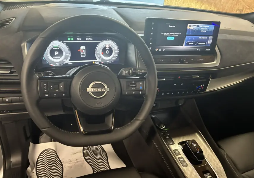 Vue intérieure du tableau de bord et volant noir du Nissan Qashqai 2025 avec écran tactile et commandes modernes.