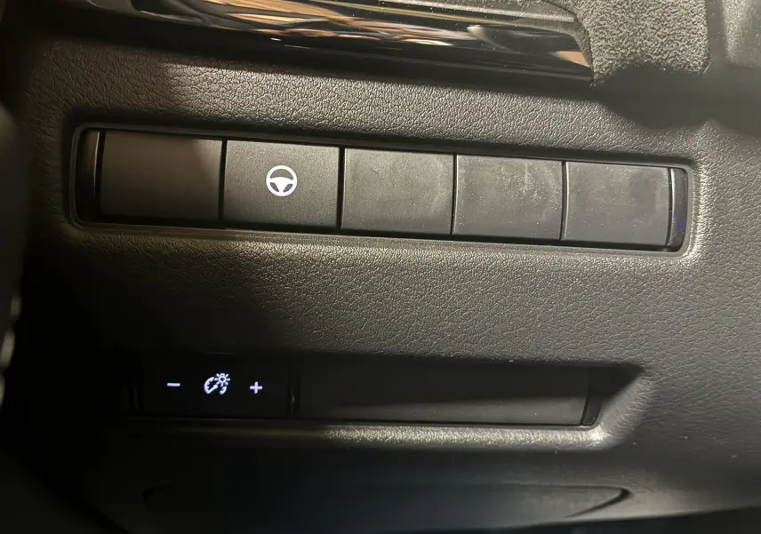 Boutons de commande du tableau de bord du Nissan Qashqai 2025, avec symbole de volant et réglage de luminosité.
