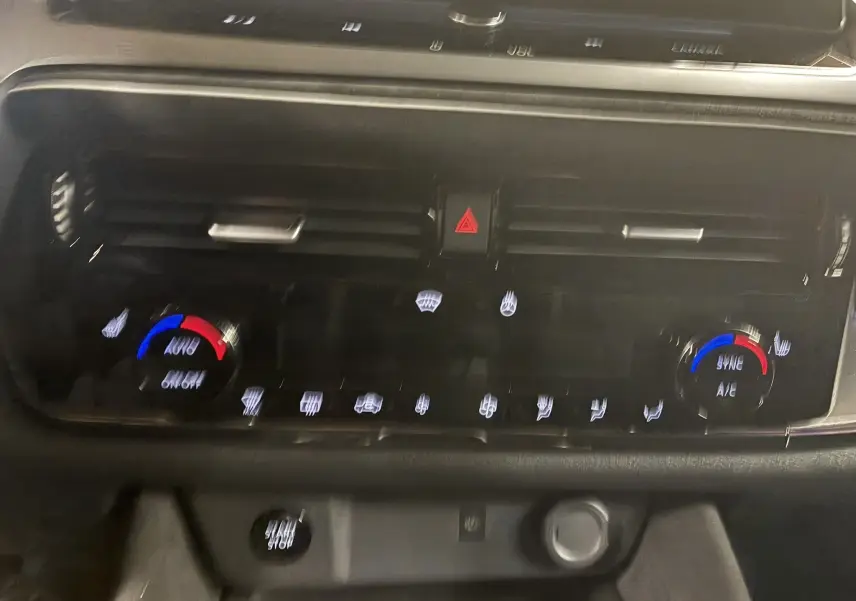 Détail du tableau de bord du Nissan Qashqai 2025 montrant la commande de climatisation automatique avec réglages bleu et rouge.
