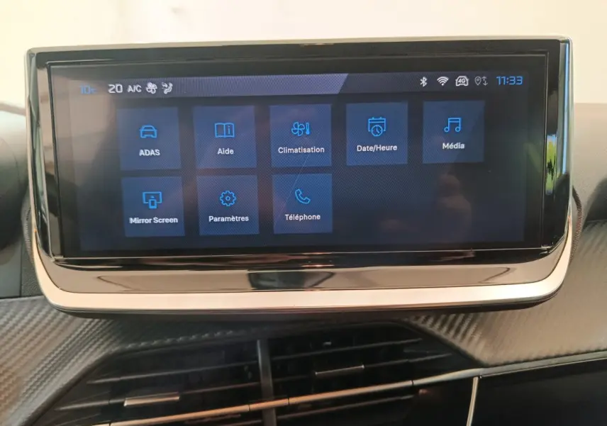 Écran tactile central de 10 pouces affichant les menus multimédias dans l’habitacle d’une Peugeot 208 gris foncé.