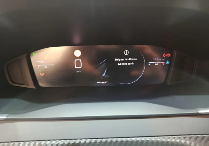 Vue rapprochée du combiné d'instruments numérique de la Peugeot 208 PureTech 100 S&S Allure affichant un message d'alerte.