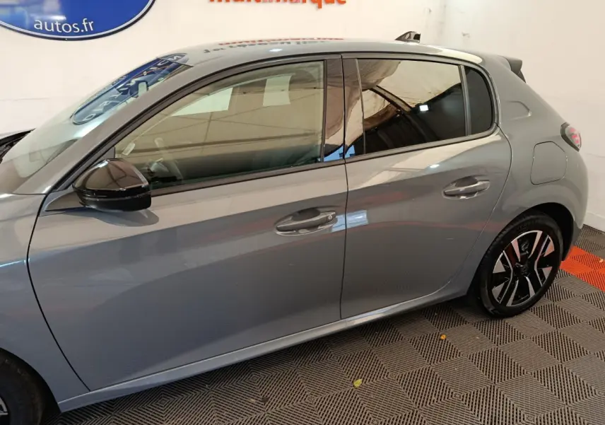 Vue latérale droite d'une Peugeot 208 gris foncé avec jantes alliage et rétroviseurs noirs brillants.