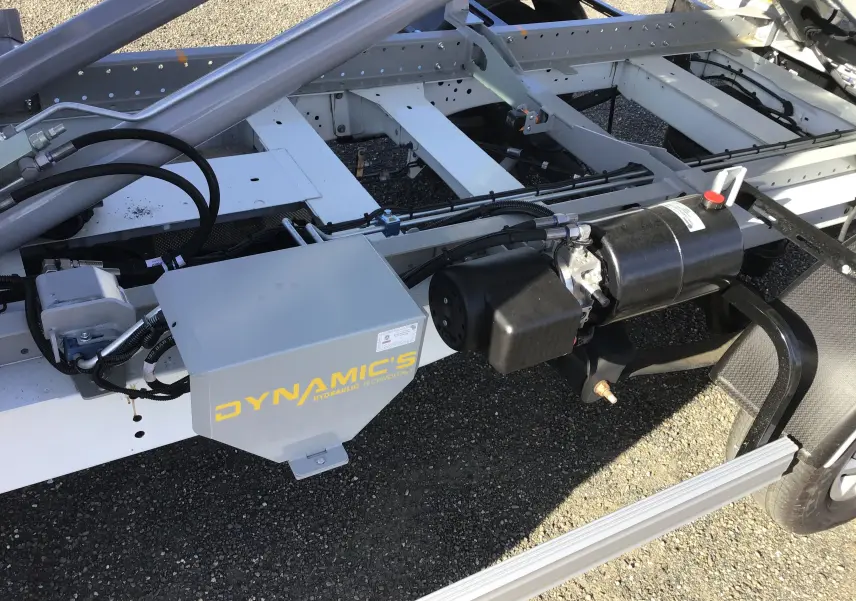 Gros plan sur le châssis blanc côté droit du Ford Transit avec système hydraulique Dynamic's visible.