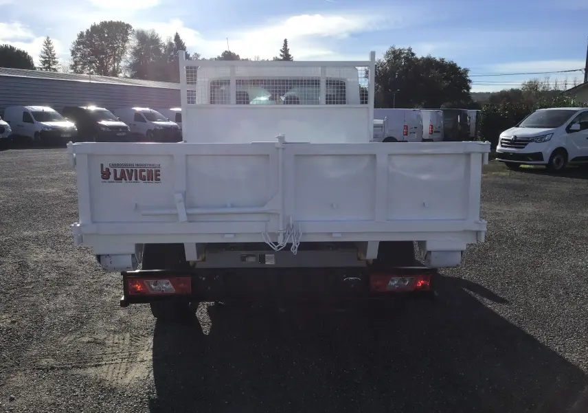 Vue arrière d'un Ford Transit Chassis Cabine blanc avec benne 3m20 et portes battantes, en extérieur.