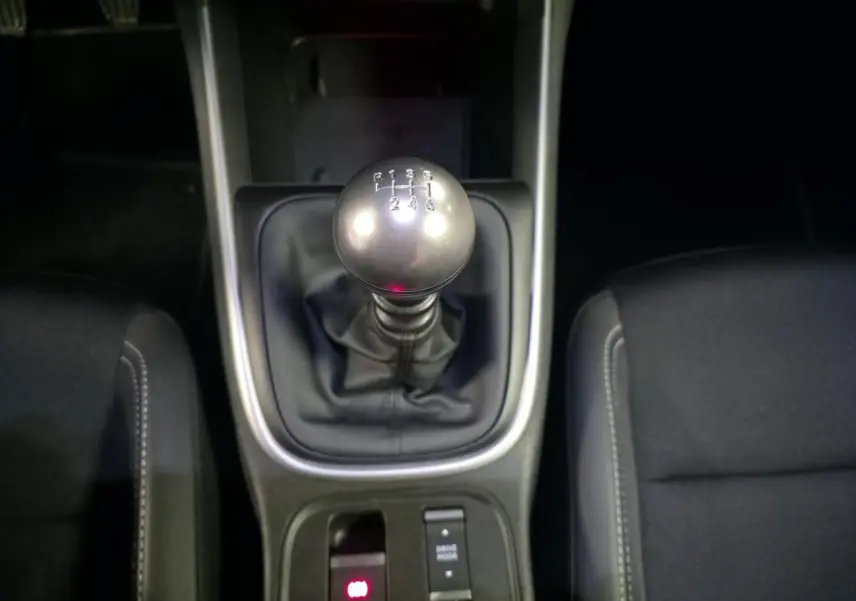 Gros plan sur le levier de vitesses manuel et la console centrale noire du Jeep Avenger 2025, sellerie tissu noir visible.