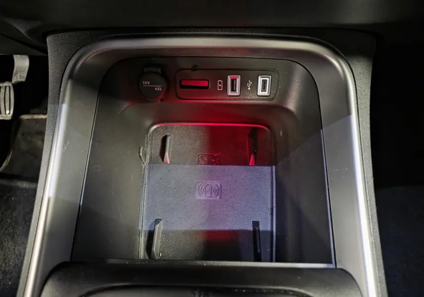 Gros plan sur la console centrale noire du Jeep Avenger 2025 avec chargeur sans fil et prises USB visibles.