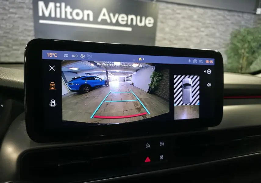 Écran tactile intérieur montrant la caméra de recul avec vue arrière et image 360°, tableau de bord noir.