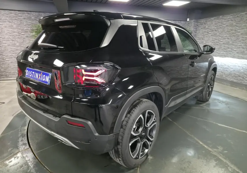 Jeep Avenger noir en vue 3/4 arrière droit, avec feux arrière LED et jantes alliage 18 pouces distinctives.