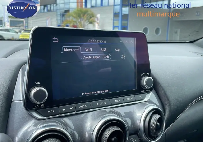Écran tactile central affichant les options de connexion Bluetooth, WiFi, USB dans l'habitacle gris perle métallique du Nissan Juke Hybrid 2023.