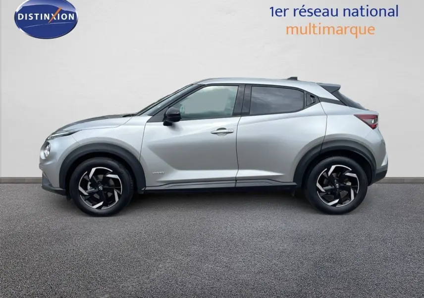 Profil côté gauche d'un Nissan Juke Hybrid 143ch Business+ gris perle métal avec jantes noires et toit foncé.
