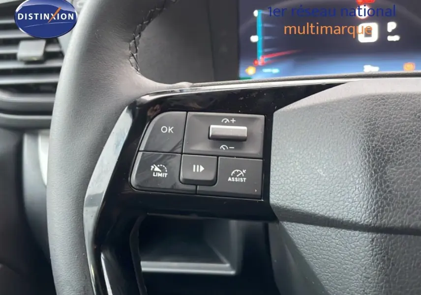 Gros plan sur les commandes au volant du Citroën Jumpy Cabine Approfondie gris titane, avec affichage numérique en arrière-plan.