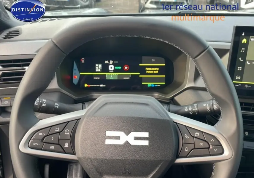 Vue centrée sur le volant cuir du Dacia Bigster gris schiste avec tableau de bord numérique allumé.