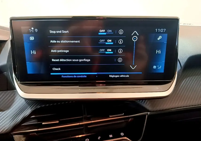 Écran tactile central de la Peugeot 208 jaune, affichant les réglages d'aide à la conduite, vue intérieure frontale.
