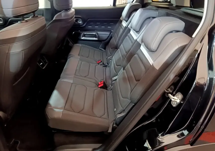 Vue côté droit sur les sièges arrière noirs du Citroën C5 Aircross hybride rechargeable 2022 avec portes ouvertes.