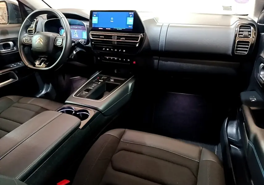 Vue intérieure côté conducteur du Citroën C5 Aircross hybride noir, avec tableau de bord digital et écran tactile central.