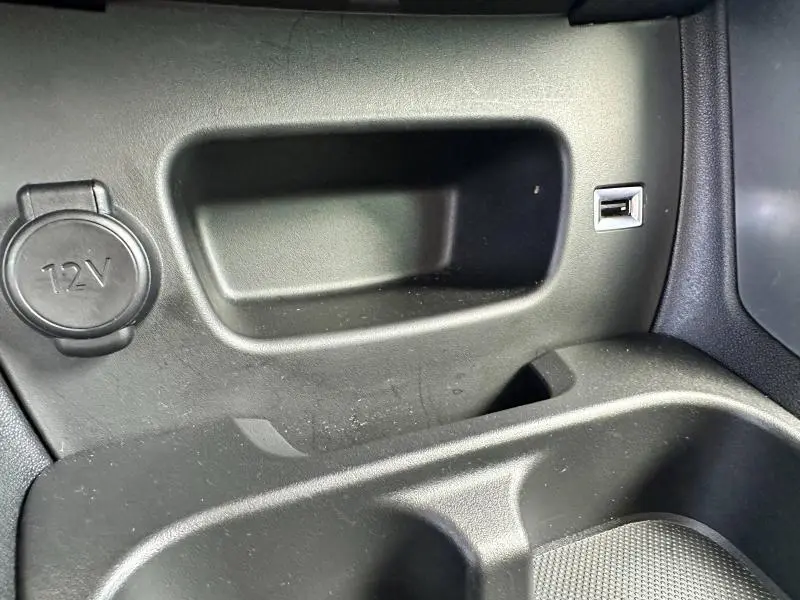 Prise 12V et port USB intégrés dans la console centrale noire d'une Citroën C3 Aircross PureTech 110ch Shine 2021.