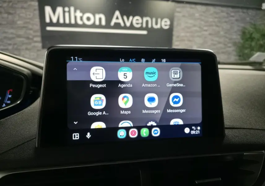 Écran tactile central du Peugeot 5008 bleu de 2019 affichant des applications connectées, intérieur sombre.