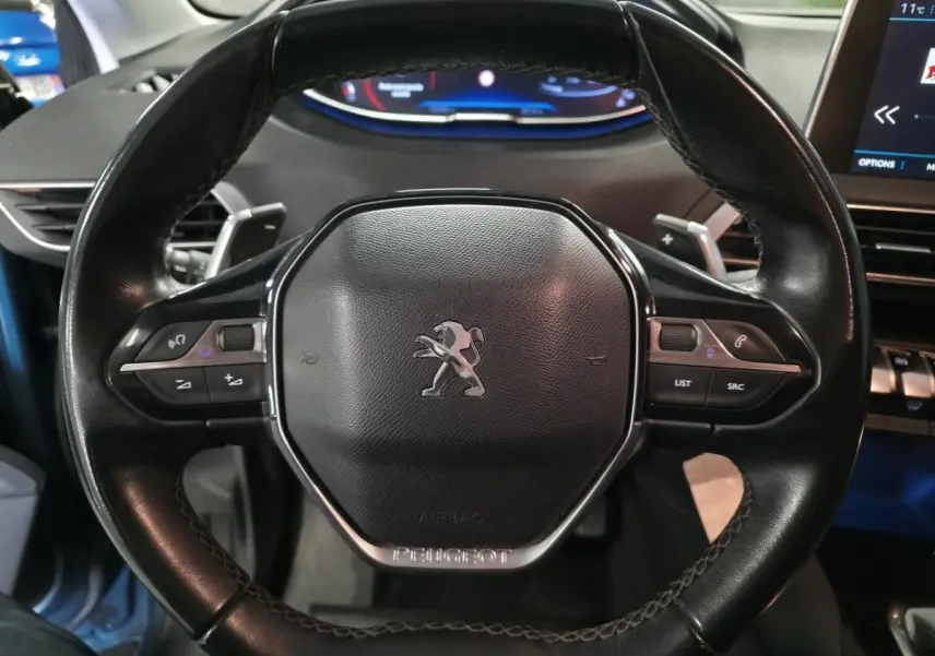 Volant cuir noir de Peugeot 5008 2019 vu de face avec commandes intégrées et tableau de bord numérique en arrière-plan.
