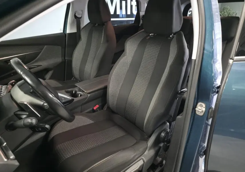 Vue intérieure côté gauche du Peugeot 5008 bleu 2019, mettant en valeur les sièges tissu Meco et l'accoudoir central.