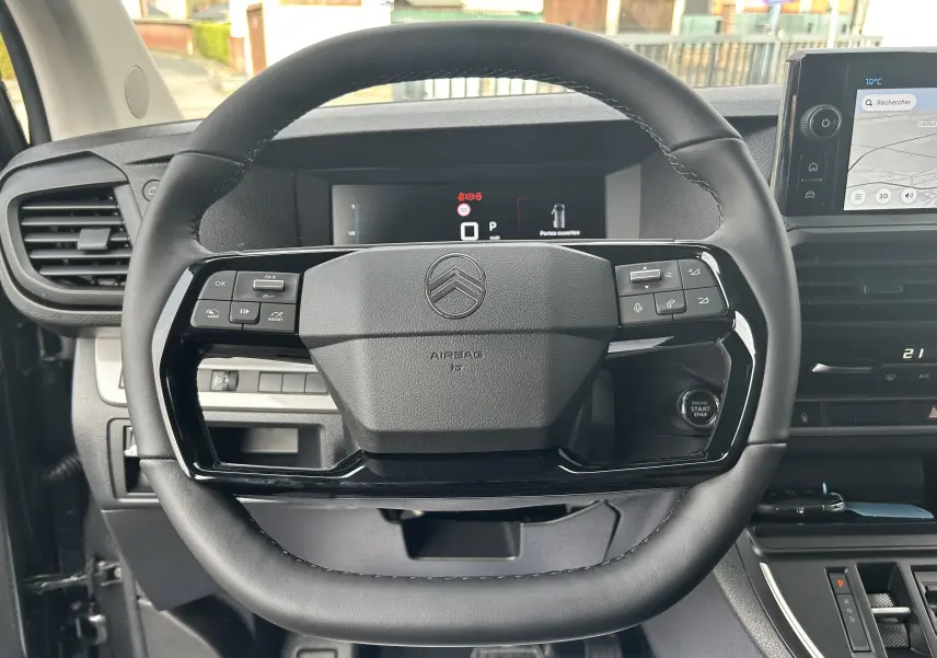 Vue rapprochée du volant noir du Citroën Jumpy Cabine Approfondie 2025 avec commandes intégrées et tableau de bord numérique.